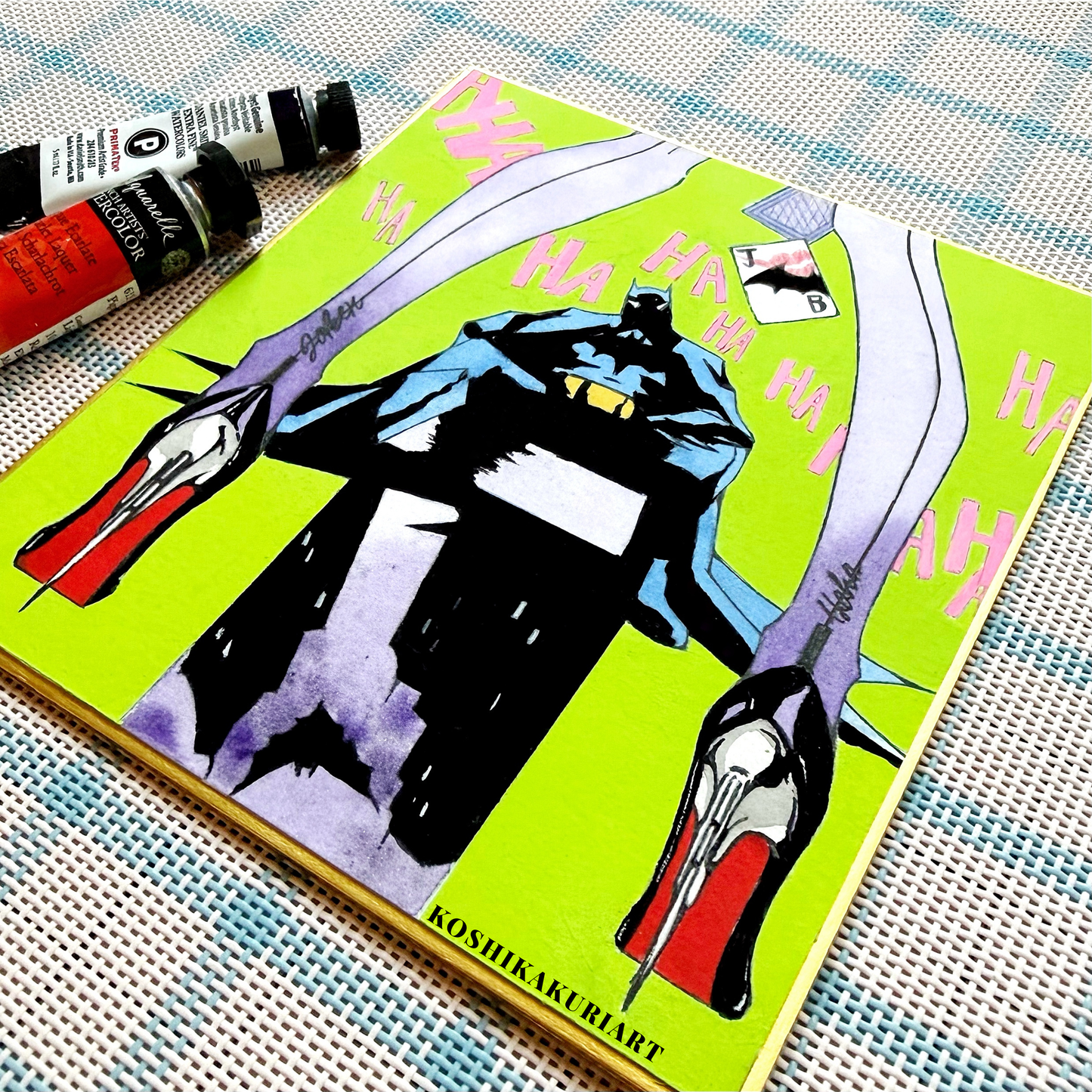 Close-up of "Red Sole" Batman Joker watercolor painting showing Daniel Smith mineral granulation on gold-edged Japanese Shikishi board.