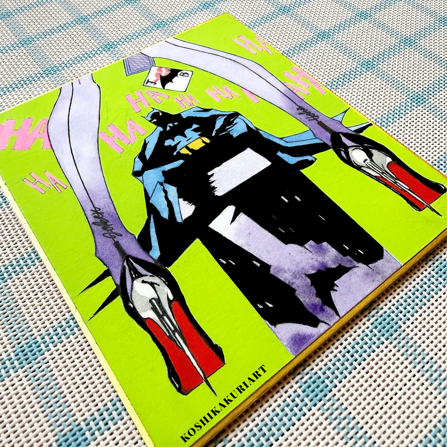 Close-up of "Red Sole" Batman Joker watercolor painting showing Daniel Smith mineral granulation on gold-edged Japanese Shikishi board.